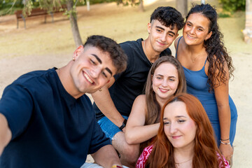 Obraz premium Group of generation z friends taking a selfie in a park