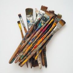 Obraz premium A collection of used and dirty paint brushes with wooden handles and bristles, isolated on a white background