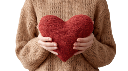 Person holding a cozy red knitted heart pillow, wearing a warm sweater, symbolizing love and comfort.