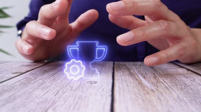 hands of a person protecting a luminous icon of a trophy with a gear on a table