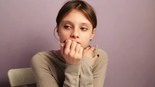 Fun emotion gesturing fingers young woman doing home school work sitting at the home table with thinking eyes. Closeup expression facial portrait video. Back to school concept