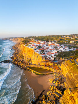 Azenhas do Mar Village in Portugal at Fiery Sunset, Cliffs and Waves of Atlantic Ocean. Aerial Drone Shot