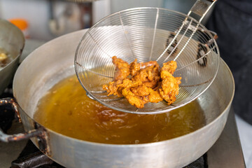 Chef frying fish in a seafood restaurant kitchen