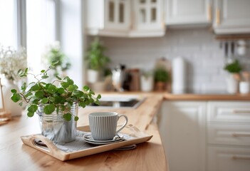 Obraz premium A wooden tray with a small plant, cup, and saucer sits on a light wooden countertop in a bright kitchen