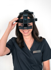 Ophthalmologist doctor with a forehead ophthalmoscope before performing a diagnostic procedure on his patient.