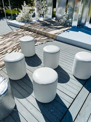 A wellorganized collection of white ottomans on a sturdy wooden deck creates a cozy atmosphere for...