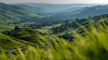 Fototapeta premium Verdant Rolling Hills Under Hazy Sky With Distant Village green valley landscape