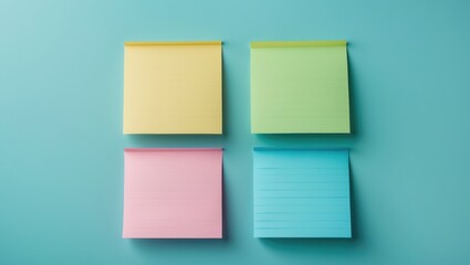 Fototapeta premium Four colorful notepads arranged in a 2x2 grid on a pastel background.
