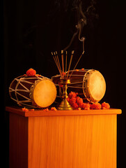 Traditional indian drums with incense and marigold flowers, symbolizing cultural and spiritual practices
