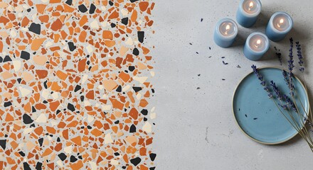 Still life featuring terrazzo pattern, blue candles, plate, and lavender on a gray textured surface ai generative