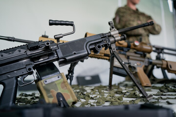 Modern military assault and sniper rifles on display with tactical camouflage setup, showing close-up of combat firearms used by armed forces in modern warfare and defense operations