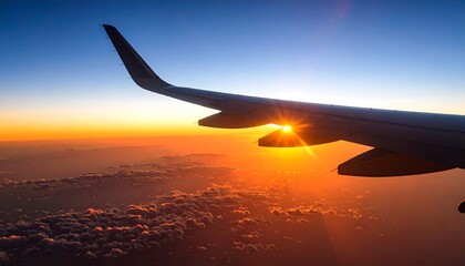 Obraz premium Airplane wing at sunset over clouds