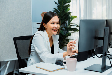 Working young Asian businesswoman thinking marketing online strategy to analyze digit report researching on website for planning channel to make sales target growth in trader business. Stratagem.