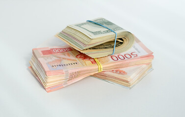 A stack of money with a yellow and blue bill on top