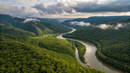 Fototapeta premium Aerial View of Serpentine River Winding Through Lush Green Mountain Valley