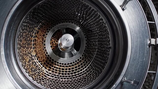 Malt grains spinning, separating inside high speed industrial centrifuge during precise beer brewing process within modern brewery machinery