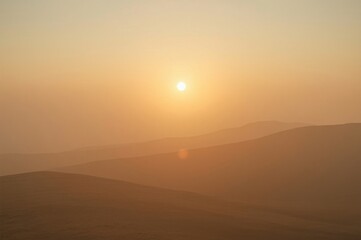 Fototapeta premium Hazy sunrise over rolling hills