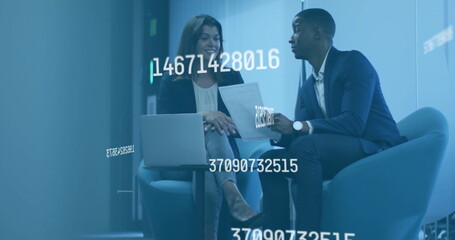 Examining floating data overlays coworkers sitting in office lounge, with laptop and tablet