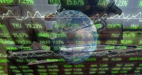 Spinning 3D Earth globe rotating in virtual financial data interface, with symbols and line charts