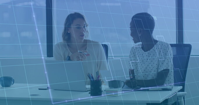 Two women collaborating on data in office meeting room, with laptop, coffee mugs, and data overlay