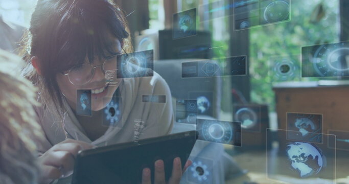 Interacting girl wearing glasses and hoodie holding tablet on grey couch, with interface overlays