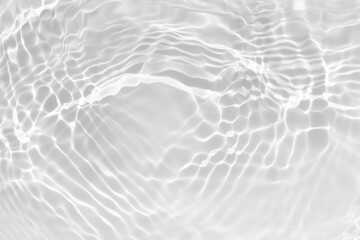 White water with ripples on the surface. Defocus blurred transparent white colored clear calm water surface texture with splashes and bubbles. Water waves with shining pattern texture background.