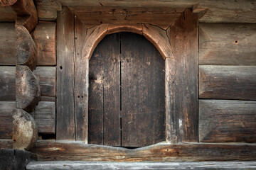 A worn wooden door in a traditional wooden hut, in a rustic style. Suitable for use in historic, rural or architectural projects.