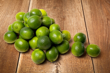 Fresh limes on a wooden table. Ideal for natural products and cooking