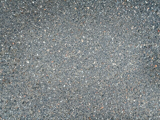 Asphalt surface background top view . Grainy road closeup. Dark gray grunge texture backdrop.