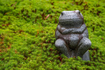 苔むした庭に置いてあるカエルの像	
