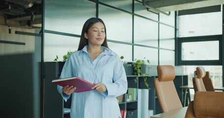 A confident woman in a sleek office holds a tablet, contemplating her next career steps and opportunities