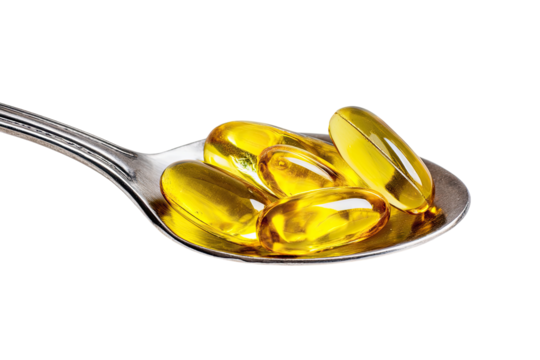 Clear yellow capsules on a spoon