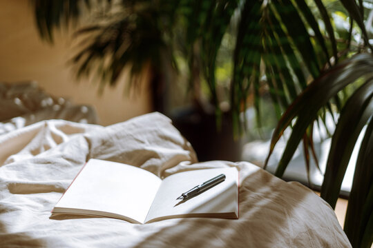 Cozy hotel bedroom with a comfortable bed and a notebook on the sheets