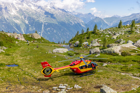 Chamonix, France - 07\07\2024: Rescue helicopter in the Alps. Heli flying high in the mountains and landing on the extreme terrain of the Alps in emergency situation. Helicopter emergency aviation