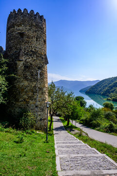 Ananuri fortress complex, Georgia, on Aragvi River. 13th century tower. Now offers serene Zhinvali Reservoir views. Clear sky, mountains in distance.