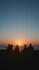 Silhouette of friends gathered on beach at sunset, enjoying a campfire.