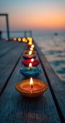 Colorful candles illuminate a wooden dock extending into a tranquil ocean at sunset
