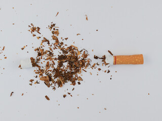 Top view Broken cigarettes and tobaccos all around the cigarettes separated on white Background. Quitting smoking concept