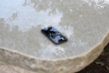 公園のピカピカの石のベンチにスマホを置いてみた