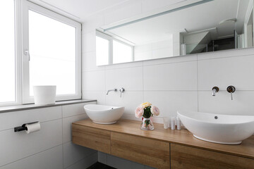 Contemporary bathroom featuring double vessel sinks, wooden vanity, white tiles and natural lighting