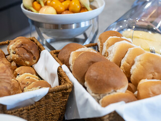 Hotel breakfast buffet showcasing variety of bread rolls and fresh fruit in professional hospitality setting