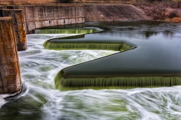 Green water flowing through a small dam