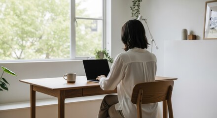 Person working at minimalist home office desk, back view