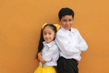 Latino older brother and younger sister play and tease each other during their free time on vacation