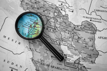 A person who is looking at the location of countries and major cities on a world map using a magnifying glass, location of the major cities of Tel Aviv in Israel, with black and white background