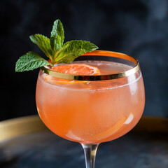 Elegant Grapefruit Cocktail with Mint Garnish and Gold Rim
