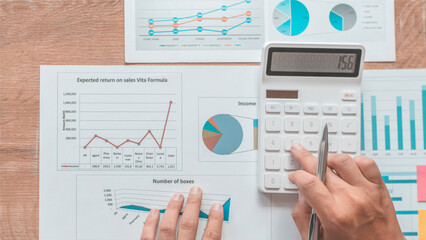 Business team analyzing financial data and marketing charts using graphs on office desk