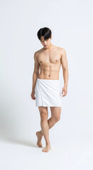 Fototapeta premium A fit Asian man in a white towel, showcasing a healthy body and skincare. Perfect for health, wellness, and beauty themes.
