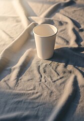 Simple elegance white paper cup on textured fabric captures minimalistic moment