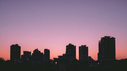 Fototapeta premium Silhouette of modern architecture against a vibrant sunset sky. 